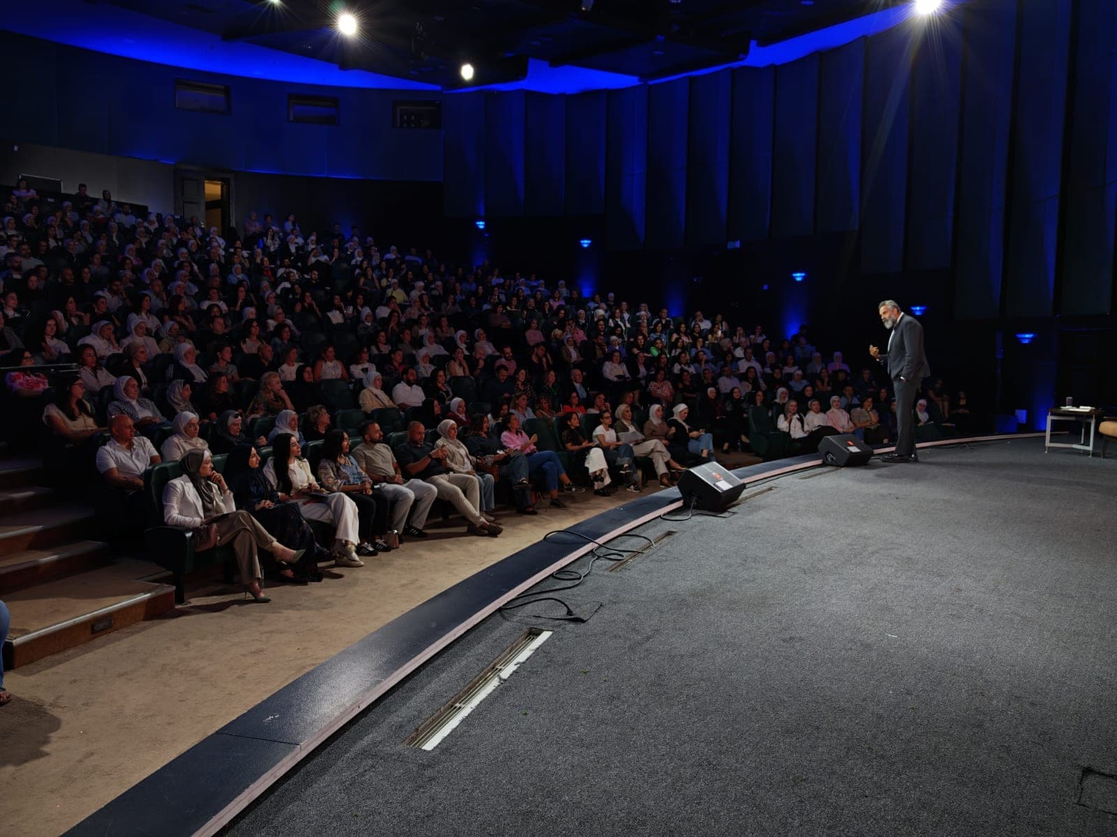 Dr. Khaled Ghattass speaking on stage before an audience