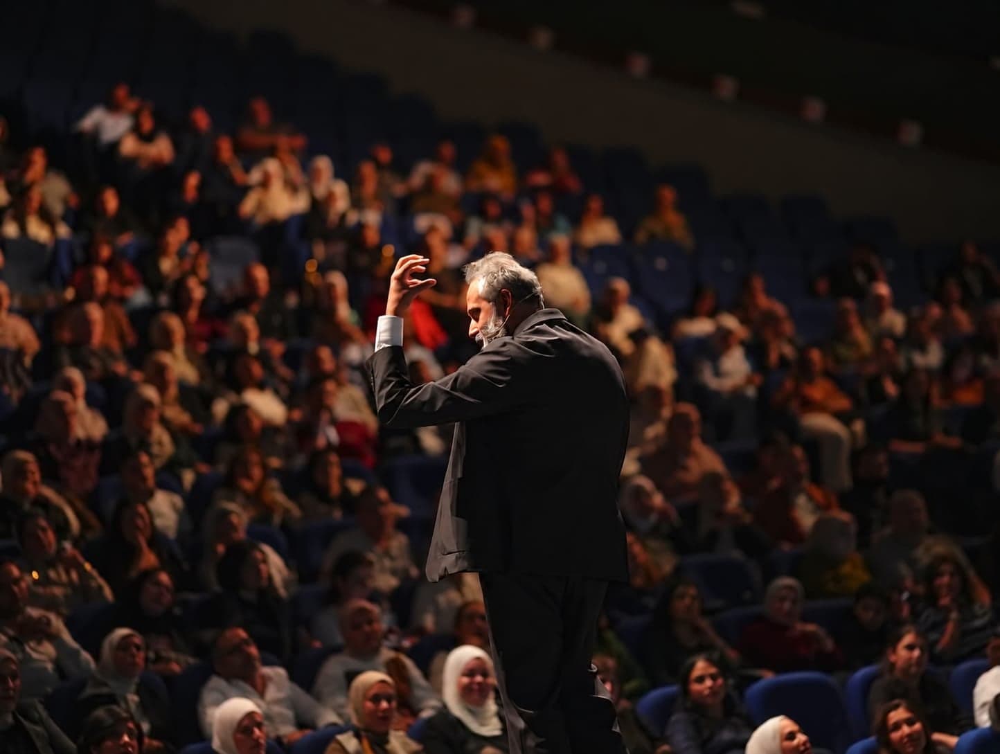 Dr. Khaled Ghattass on stage before a full auditorium